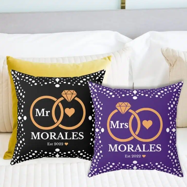 Here’s the corrected version: Black and pillow custom wedding pillows featuring intertwined rings, the couple's last name, and the year of marriage.