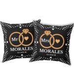 Here’s the corrected version: Black custom wedding pillows featuring intertwined rings, the couple's last name, and the year of marriage