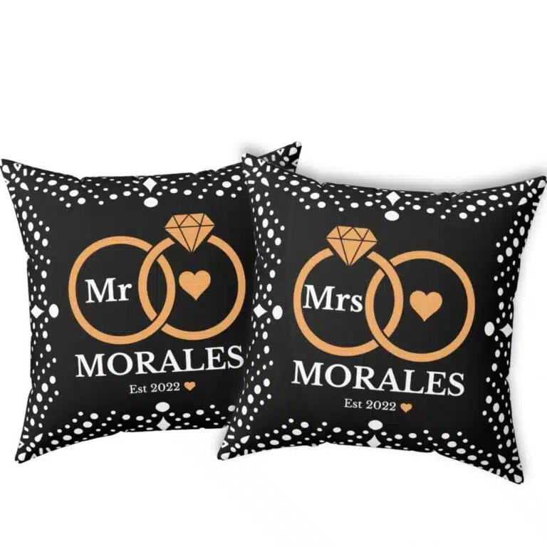 Here’s the corrected version: Black custom wedding pillows featuring intertwined rings, the couple's last name, and the year of marriage
