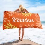Personalized tropical towel with name for her in orange – laid out to display bold tropical leaf pattern and custom name, perfect for beach days or summer gifts